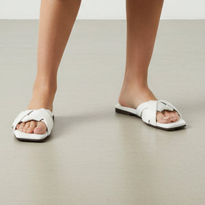 White sandals with criss-cross straps on a white background